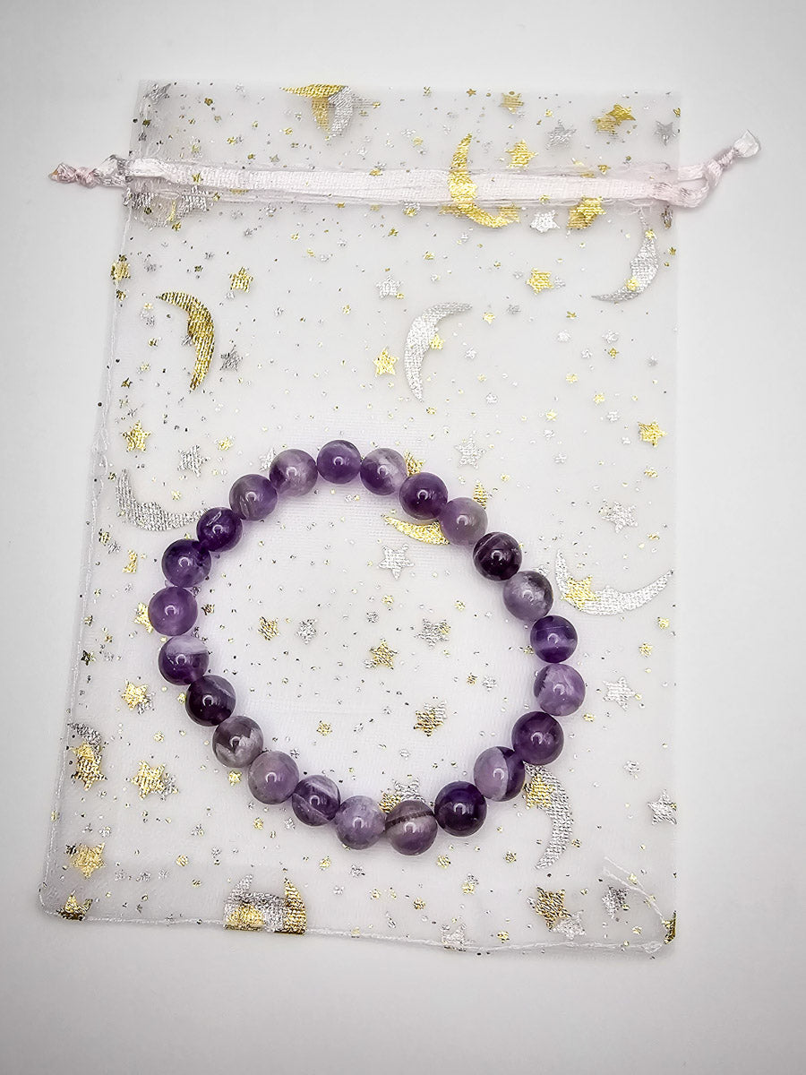 Amethyst bracelet elegantly laid on its accompanying bag, illustrating the complete, thoughtful packaging.