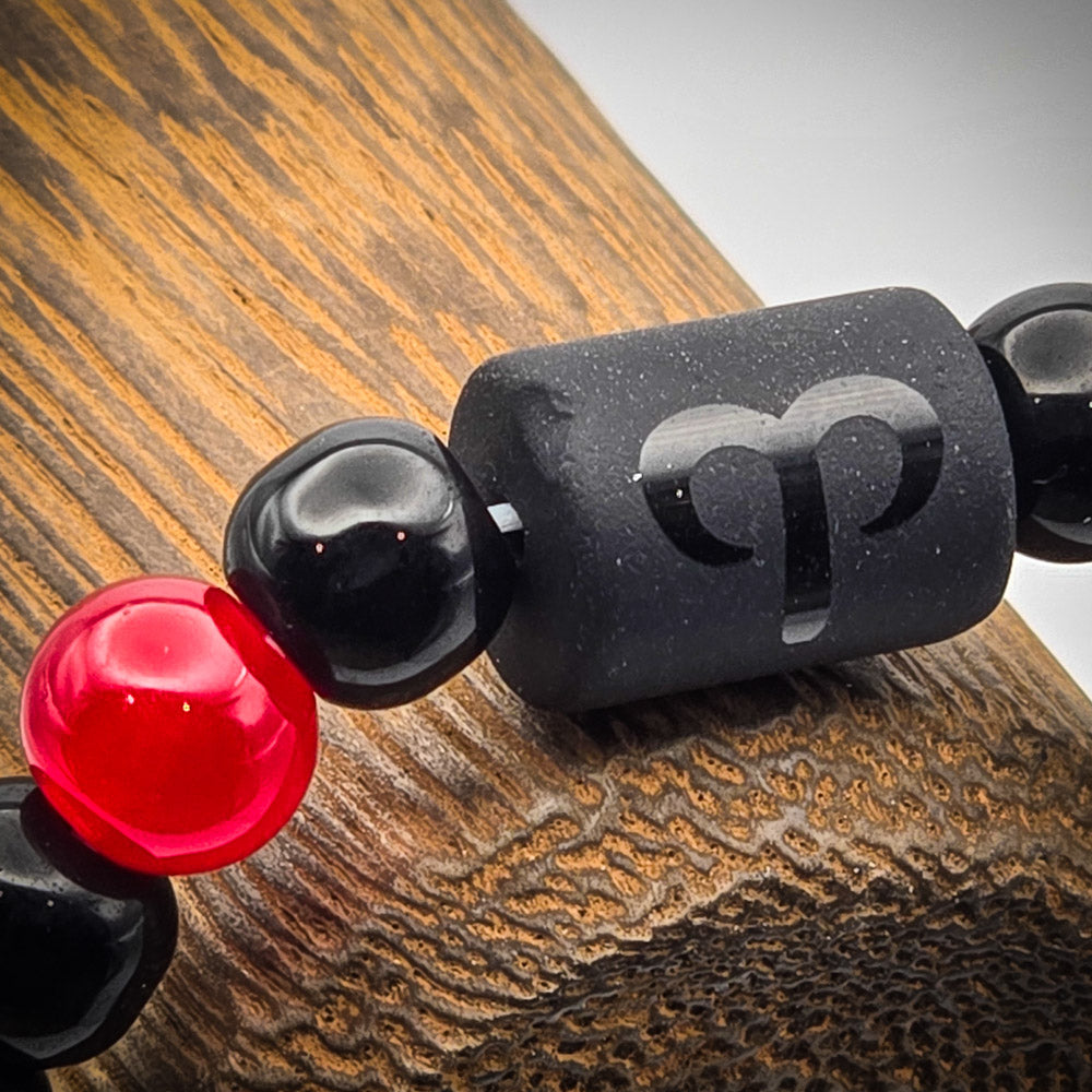 Close-up of Aries bracelet bead highlighting the engraved symbol of the Aries zodiac sign.