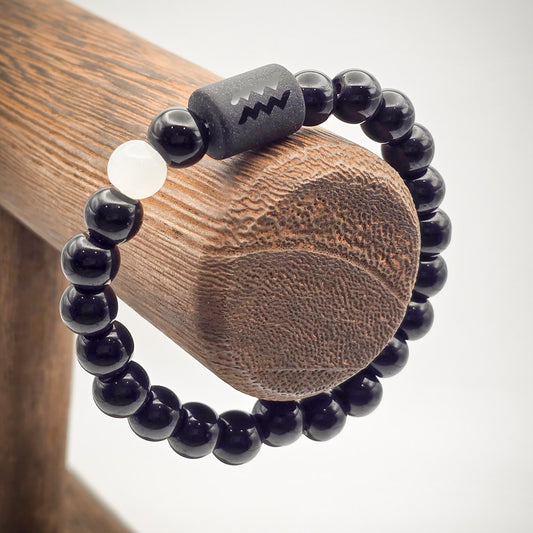 Aquarius Zodiac Bracelet displayed on a wood stand