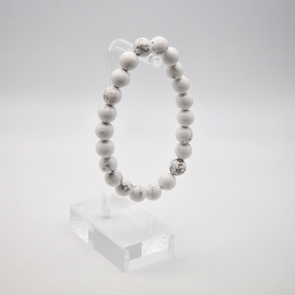 Sophisticated Howlite Bracelet Display on Acrylic Stand - A Symbol of Peaceful Communication