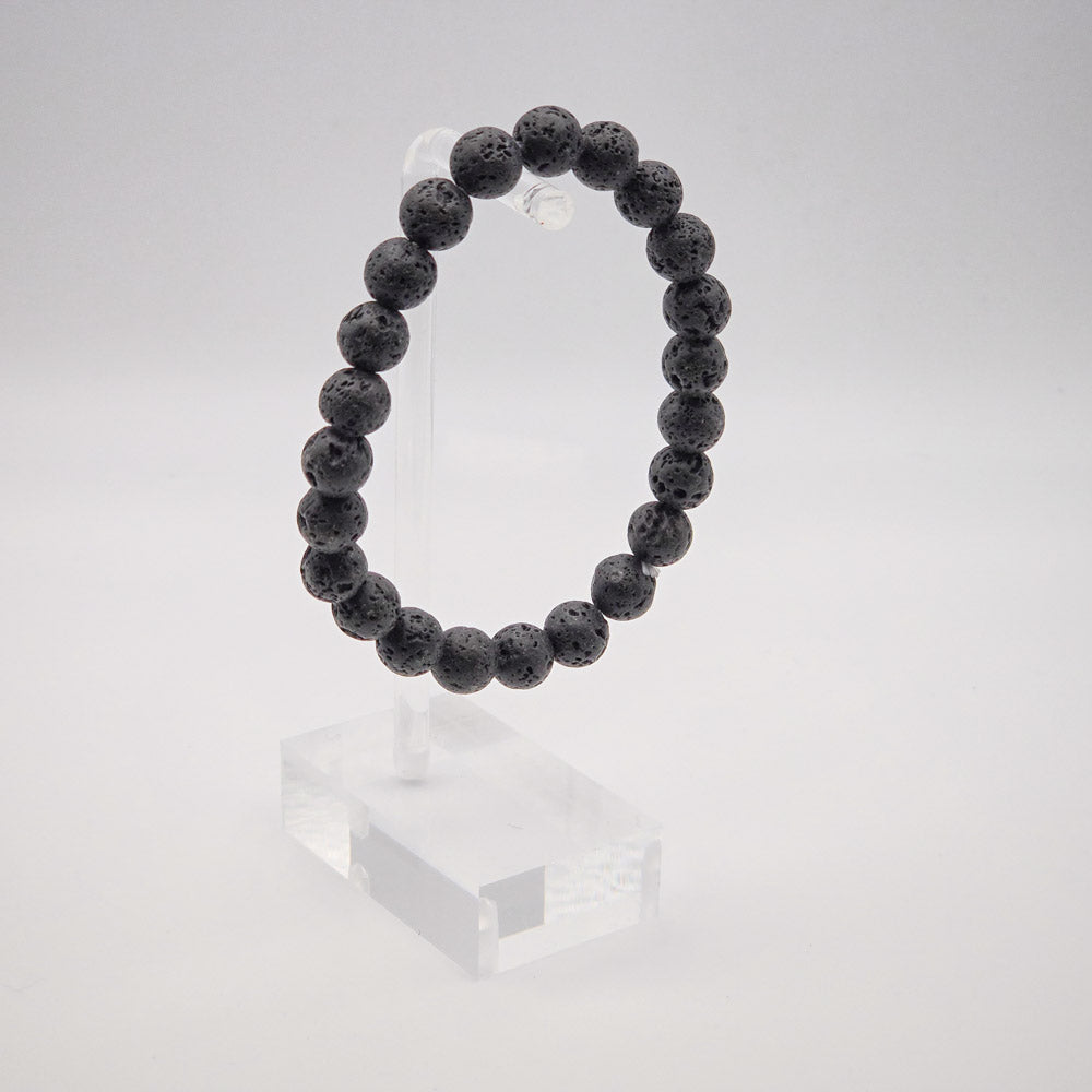 Sophisticated Lava Stone Bracelet Display on Acrylic Stand - Reflecting Tranquility and Resilience.