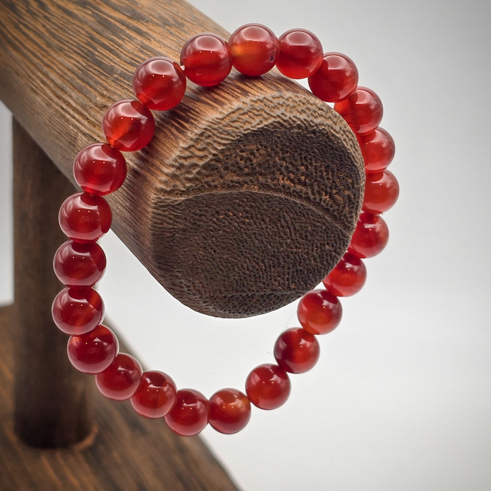 Carnelian Beaded Bracelet on Wood Stand - A Spark of Creativity and CourageDetail of Carnelian Beads - Radiant Warmth Encouraging Self-Esteem and Passion