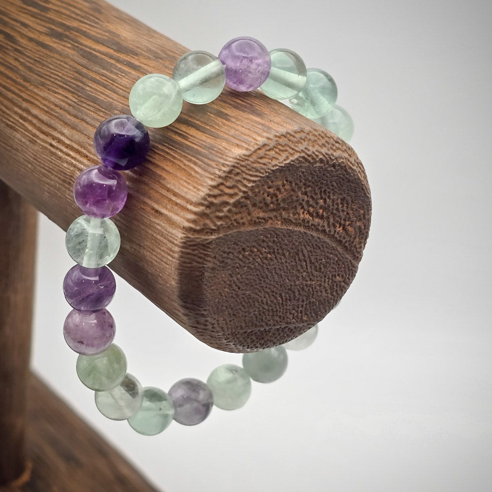 Rainbow Fluorite Beaded Bracelet on Wood Stand - A Spectrum of Protection and Calm.