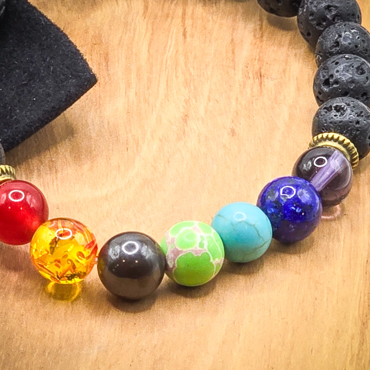 Close-up of chakra bracelet beads on a wooden background