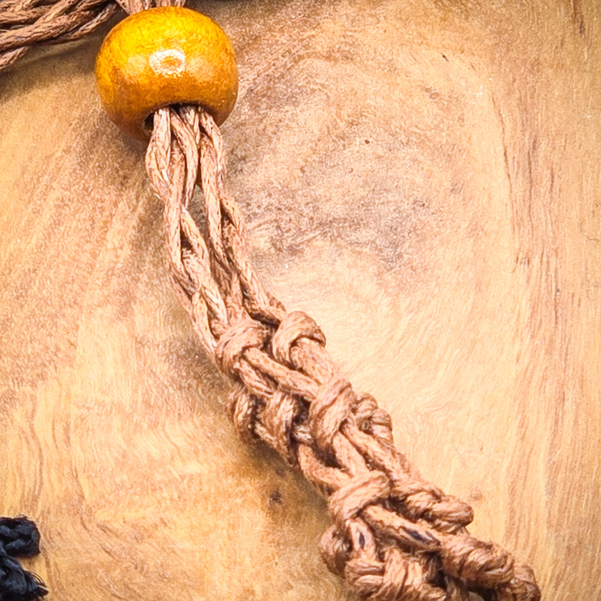 Close-up of the chakra stone necklace setup on a wood background