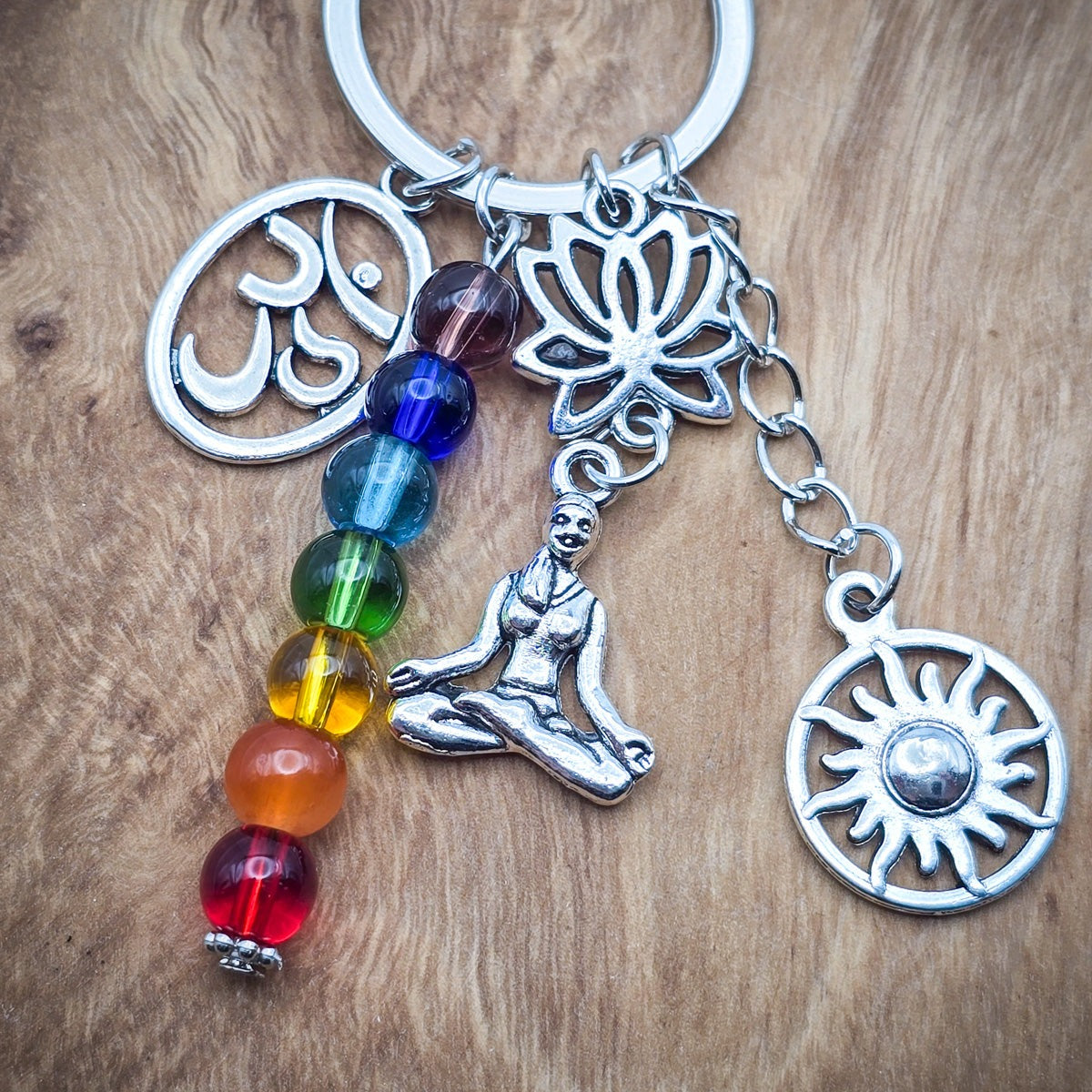 Chakra Keychain with rainbow beads and yoga-inspired charms including an Ohm symbol, meditating woman, lotus flower, and sun