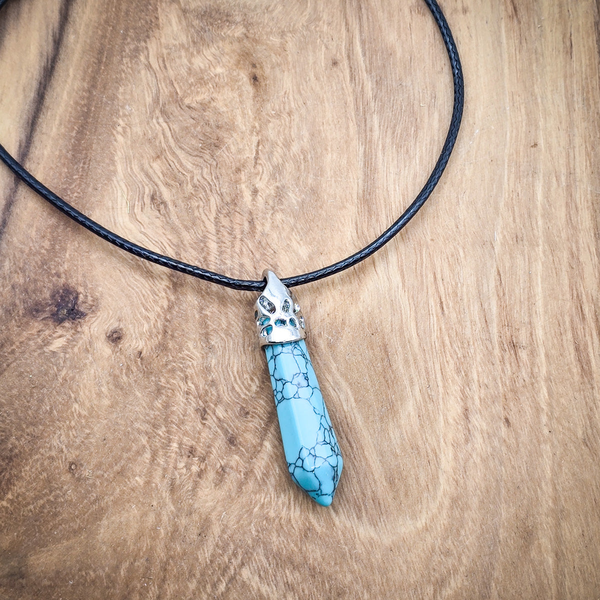 Close-up of the Turquoise hexagonal pendant, highlighting the gemstone's vibrant hues and smooth, geometric shape.