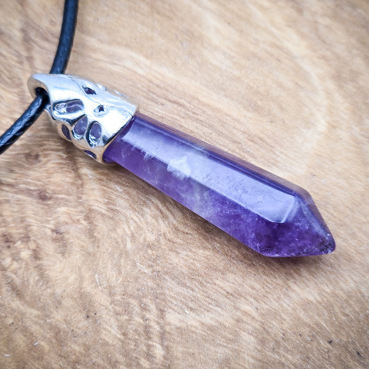 Detailed view of the Amethyst hexagonal pendant, emphasizing the deep purple hues and the clarity of its polished surface.