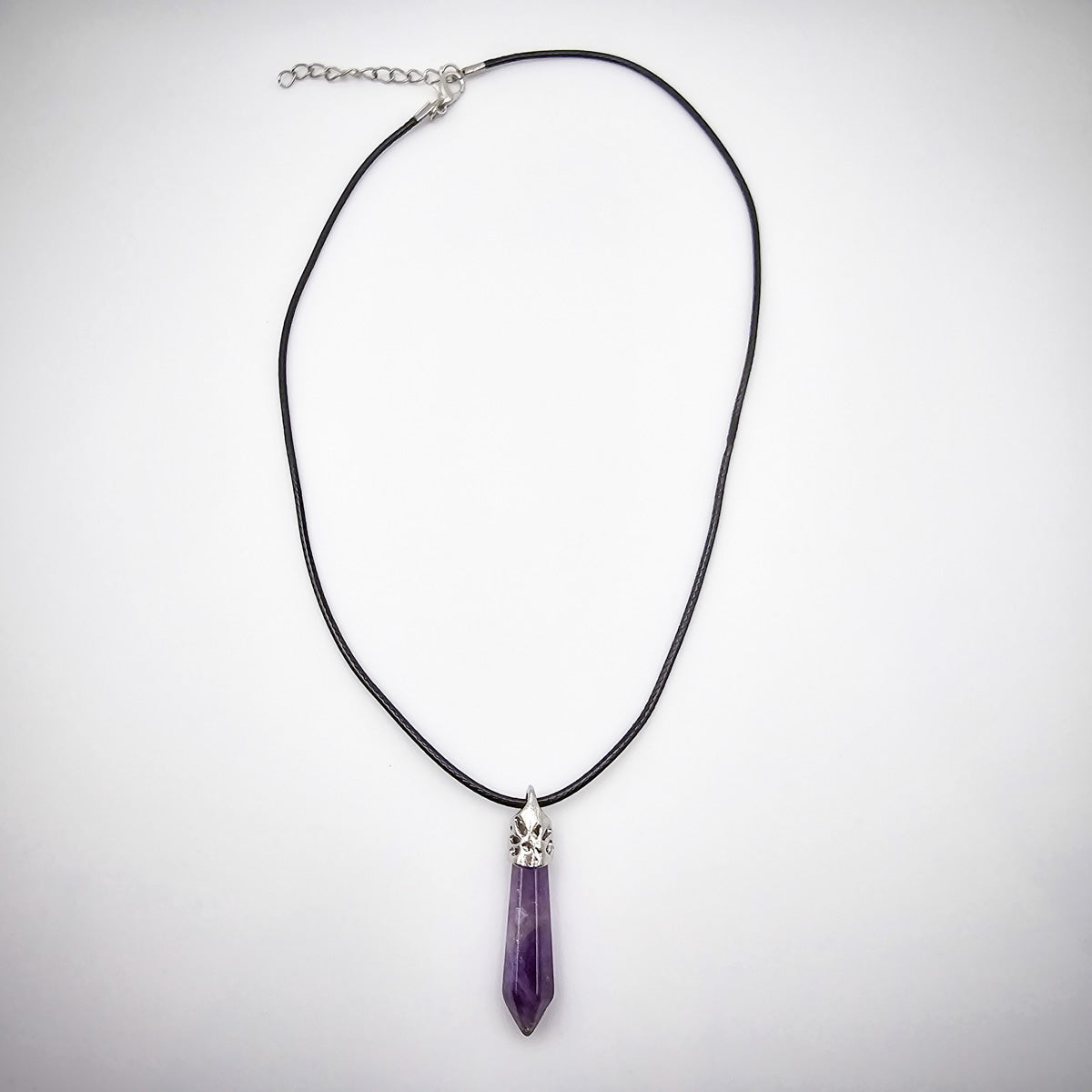 Full view of the Amethyst pendant necklace against a white backdrop, showing the sleek black cord and the pendant's serene elegance.