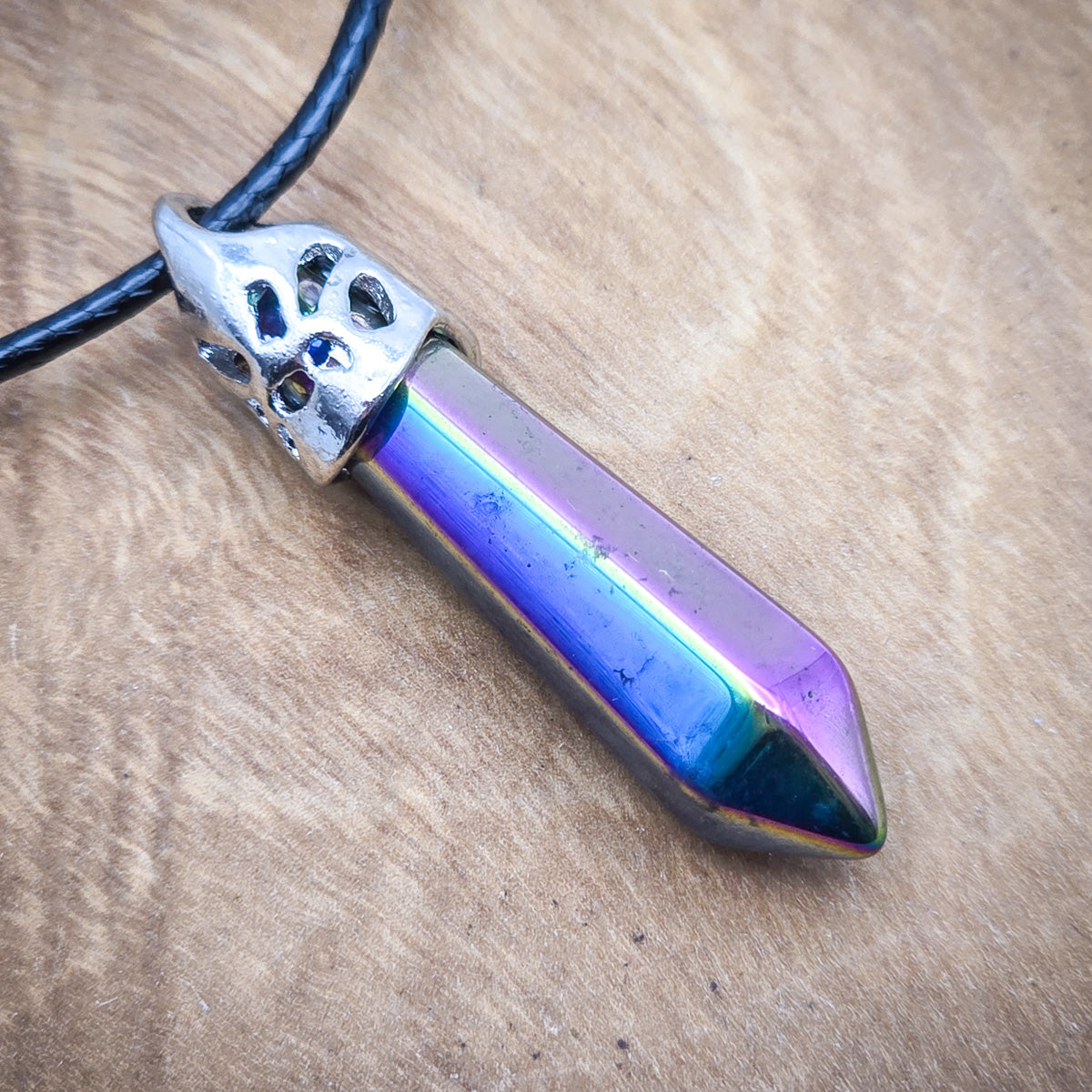 Close-up of the Titanium Aura Quartz pendant, emphasizing the vivid hues and sleek hexagonal shape.