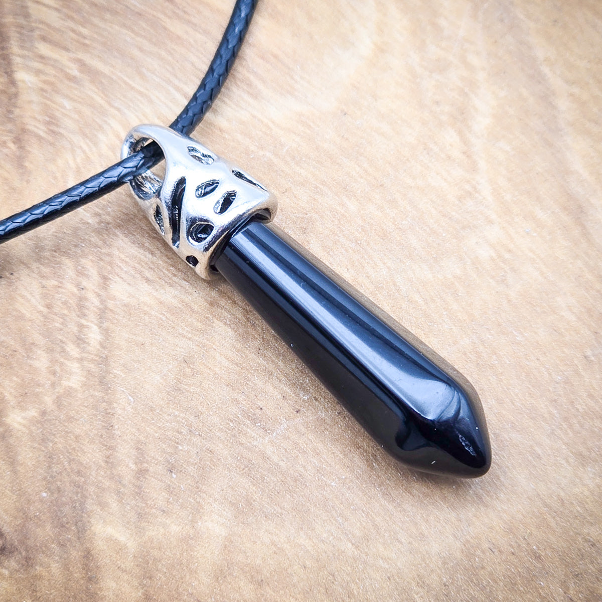 Close-up view of the Onyx hexagonal pendant, highlighting the sleek black surface and the pendant's precise, geometric form.