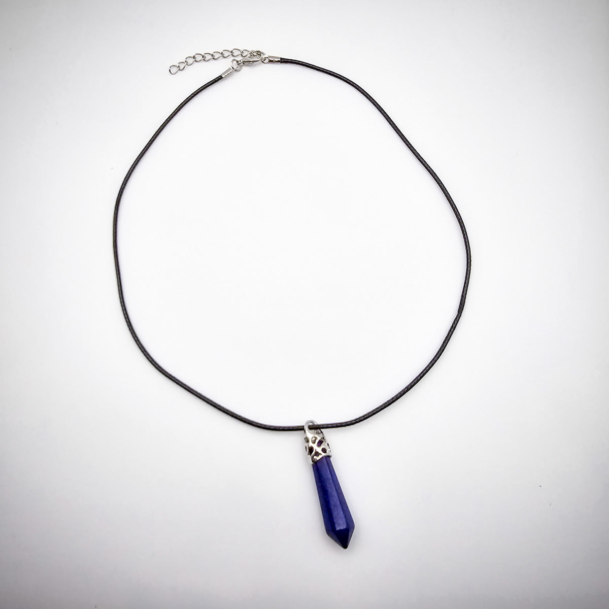 Full view of the Lapis Lazuli pendant necklace on a white background, emphasizing the elegant black cord and the pendant's symbolic beauty.