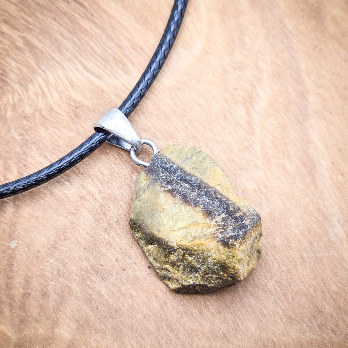 Close-up of the Tiger's Eye pendant, highlighting the unique interplay of colors and the natural beauty of the stone.