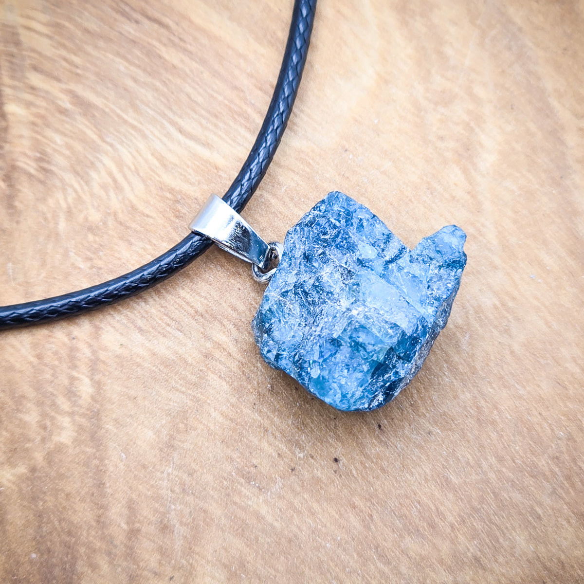 Close-up view of the Blue Apatite raw gemstone pendant, highlighting the stone's natural hues and unique beauty.