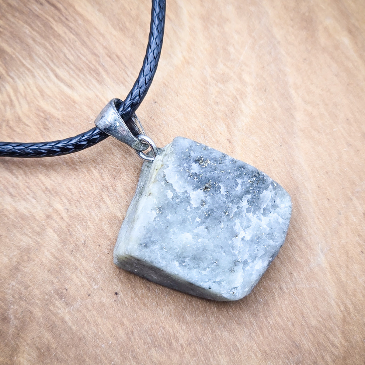 Close-up of Lapis Lazuli raw gemstone pendant detailing its unique texture and color variations.