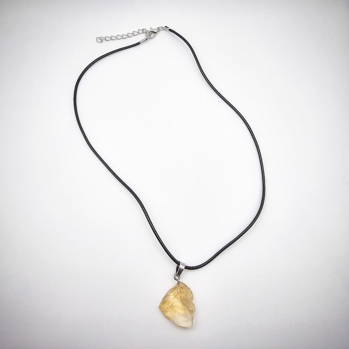 Entire Citrine pendant necklace against a white background, accentuating the black cord and the gem's natural brilliance