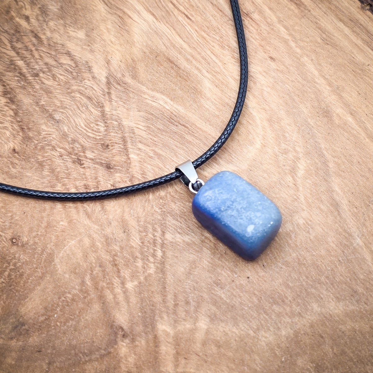 Polished Lapis Lazuli cube pendant on an 18" black cord, showcasing the stone's deep blue hues and natural golden inclusions.