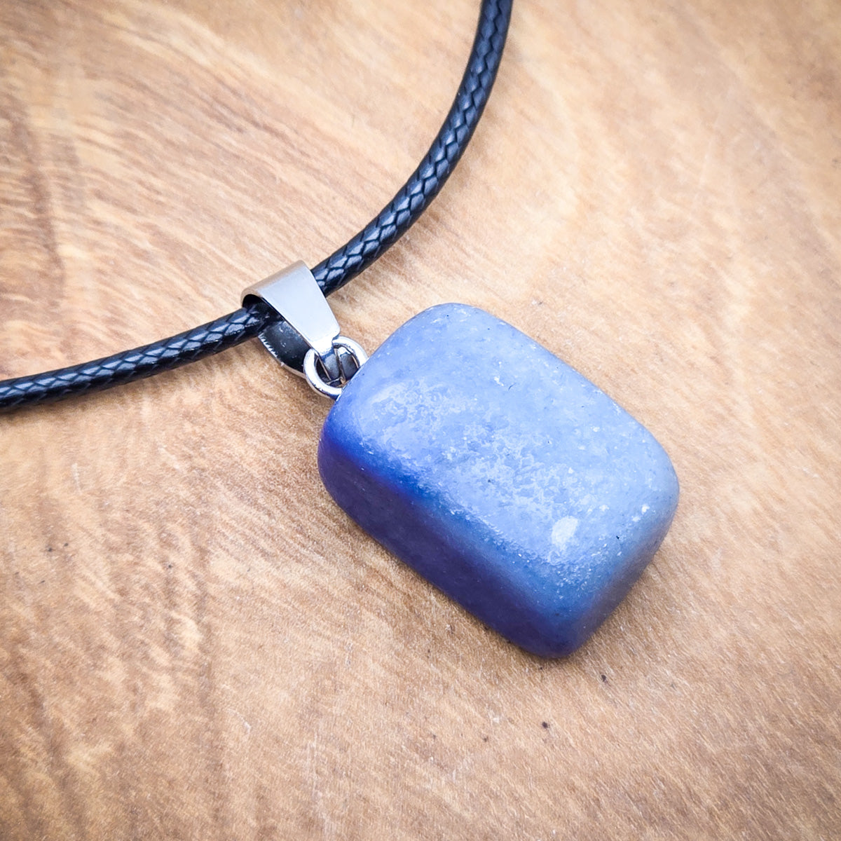 Close-up view of the Lapis Lazuli cube pendant, highlighting its mesmerizing blue color and the intricate patterns within.