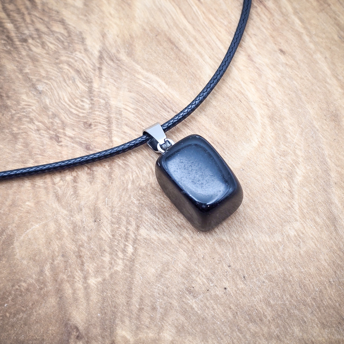 Polished Onyx cube pendant on an 18" black cord, symbolizing strength and protection with its deep black elegance.