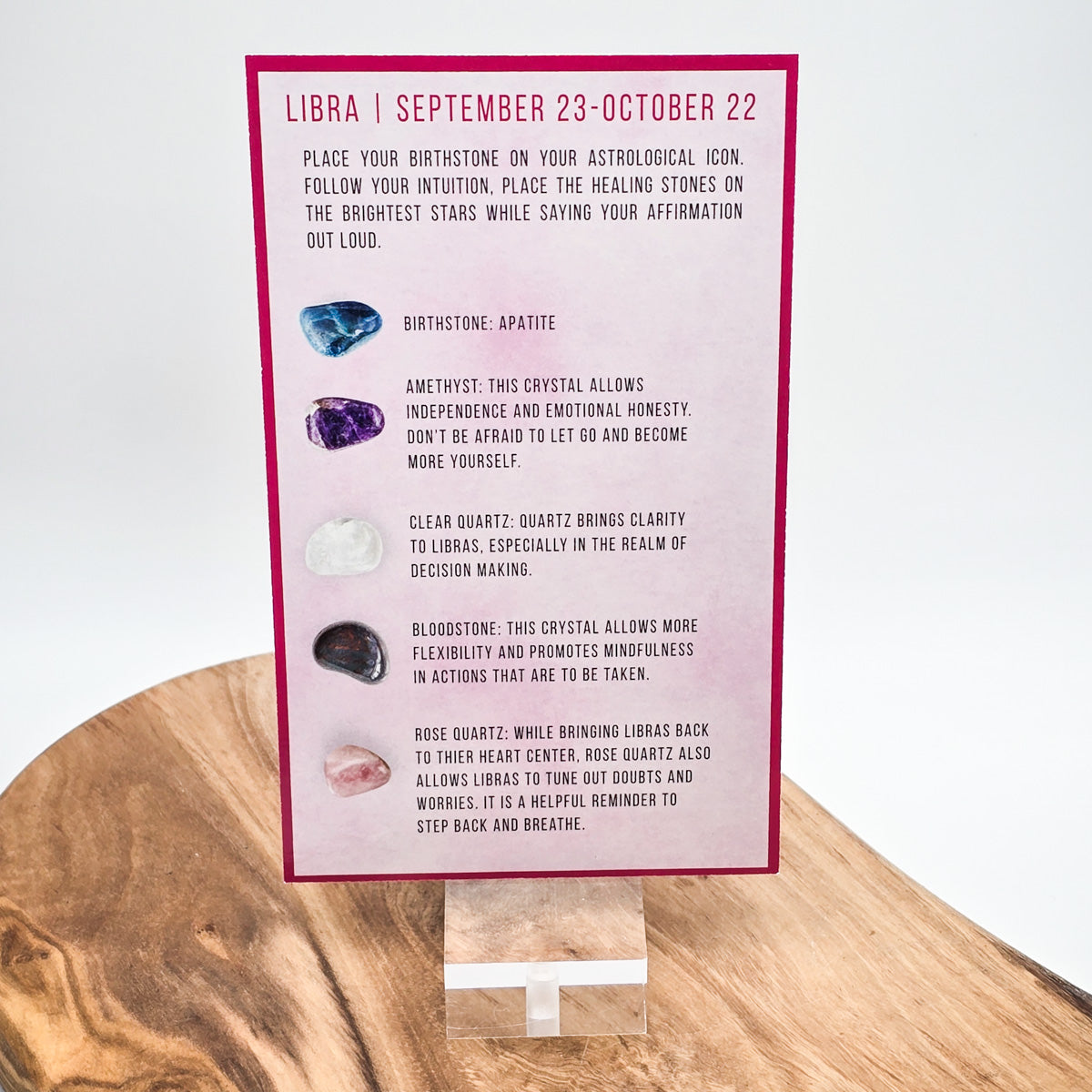 Reverse side of the Libra card showing what crystals the bag contains.  Sitting on a wood block with white background.