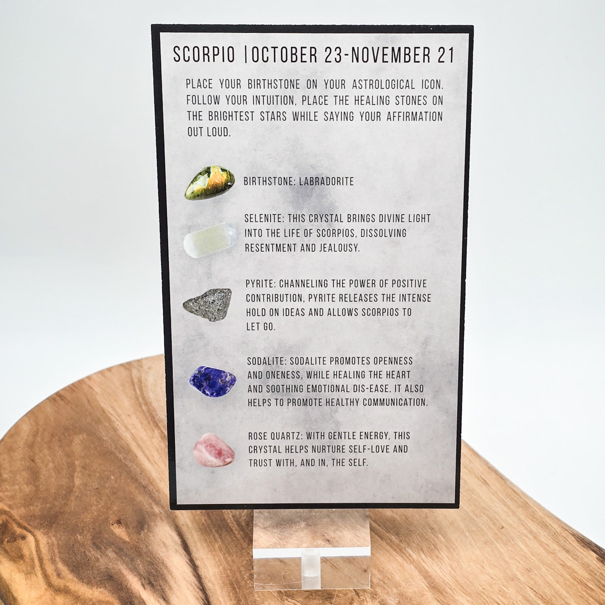 Reverse side of the Scorpio card showing what crystals the bag contains.  Sitting on a wood block with white background.