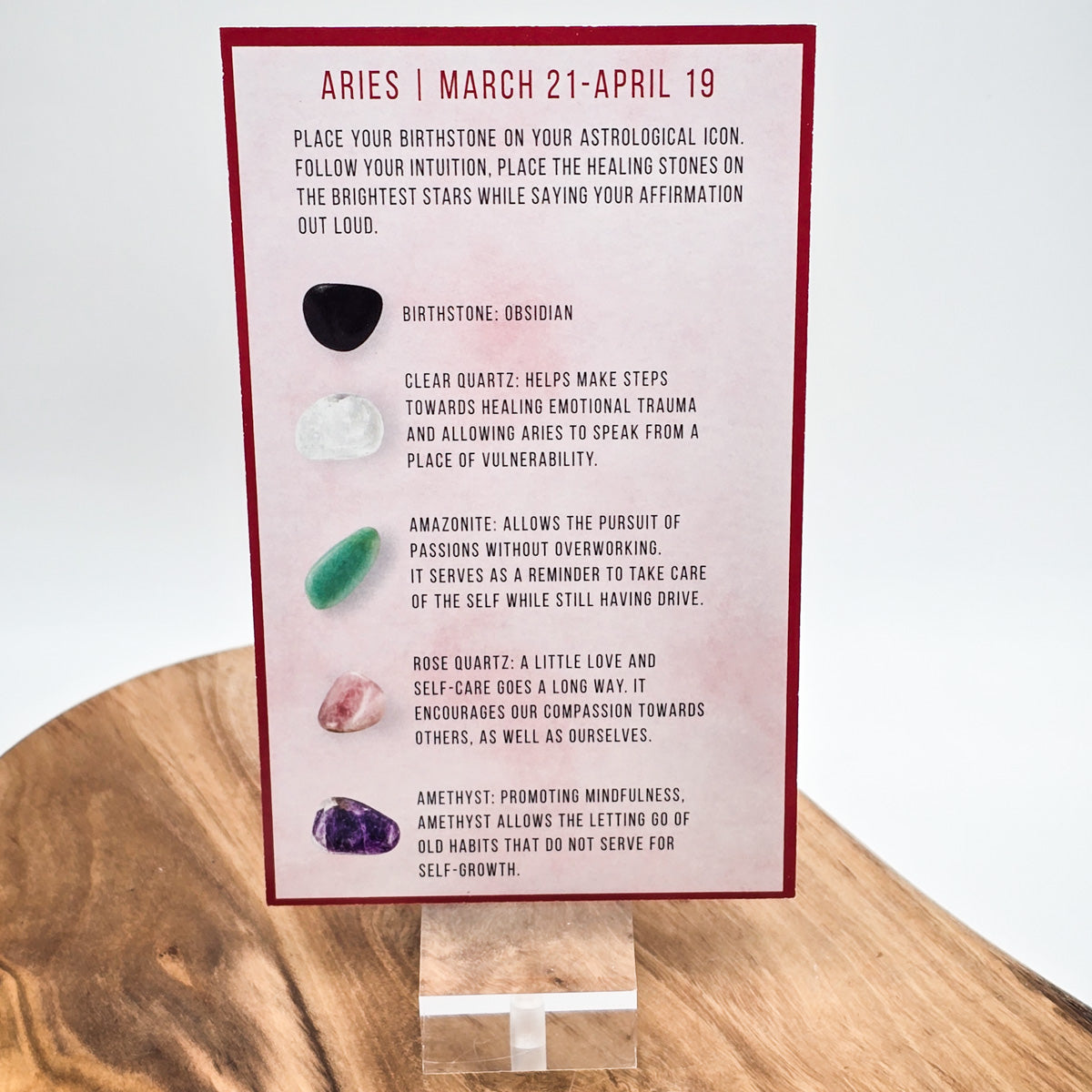 Reverse side of the Aries card showing what crystals the bag contains.  Sitting on a wood block with white background.