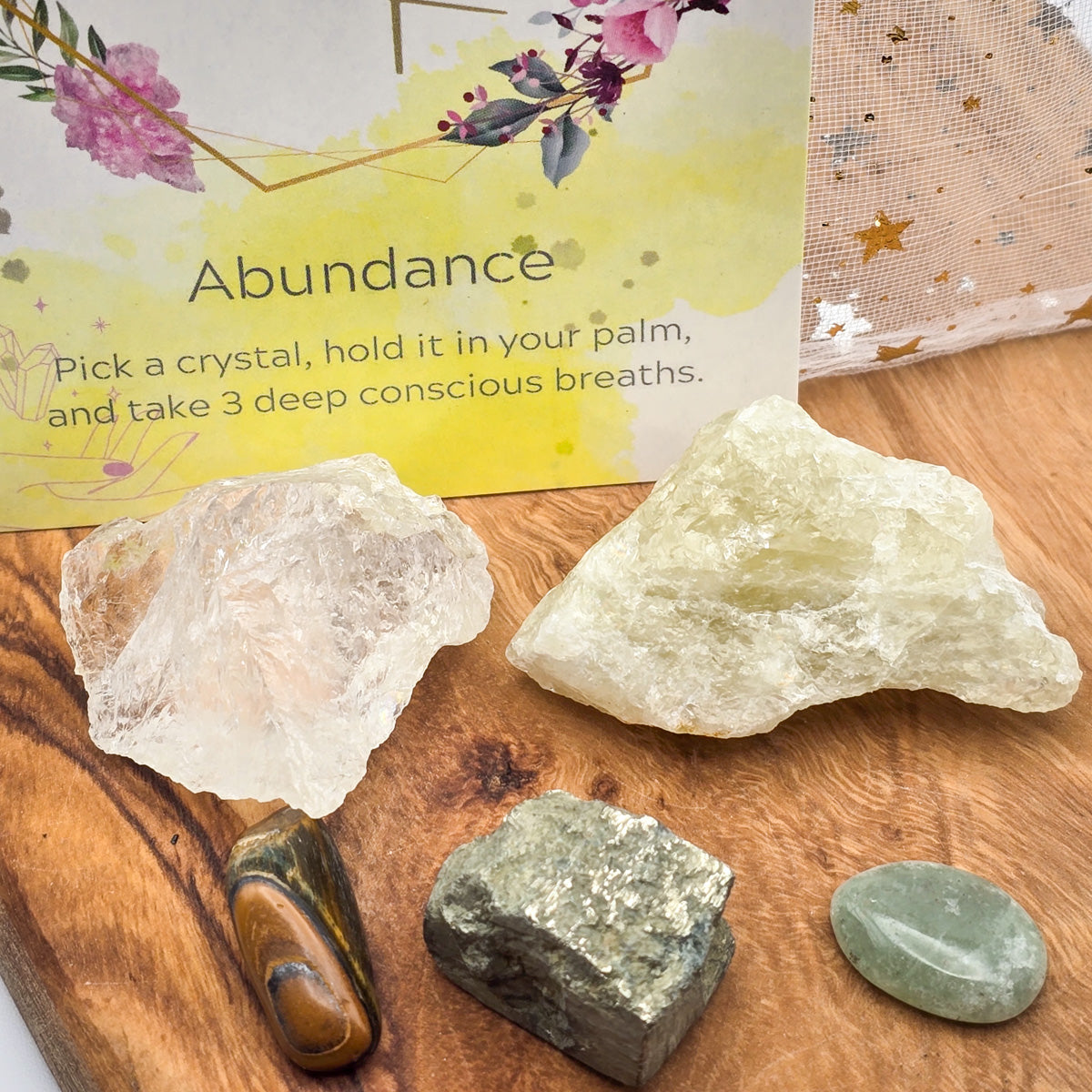 Close-up view of the 'Abundance & Prosperity' Mojo Bag's crystals, with the card's title in view, hinting at the wealth-enhancing energies of the stones.