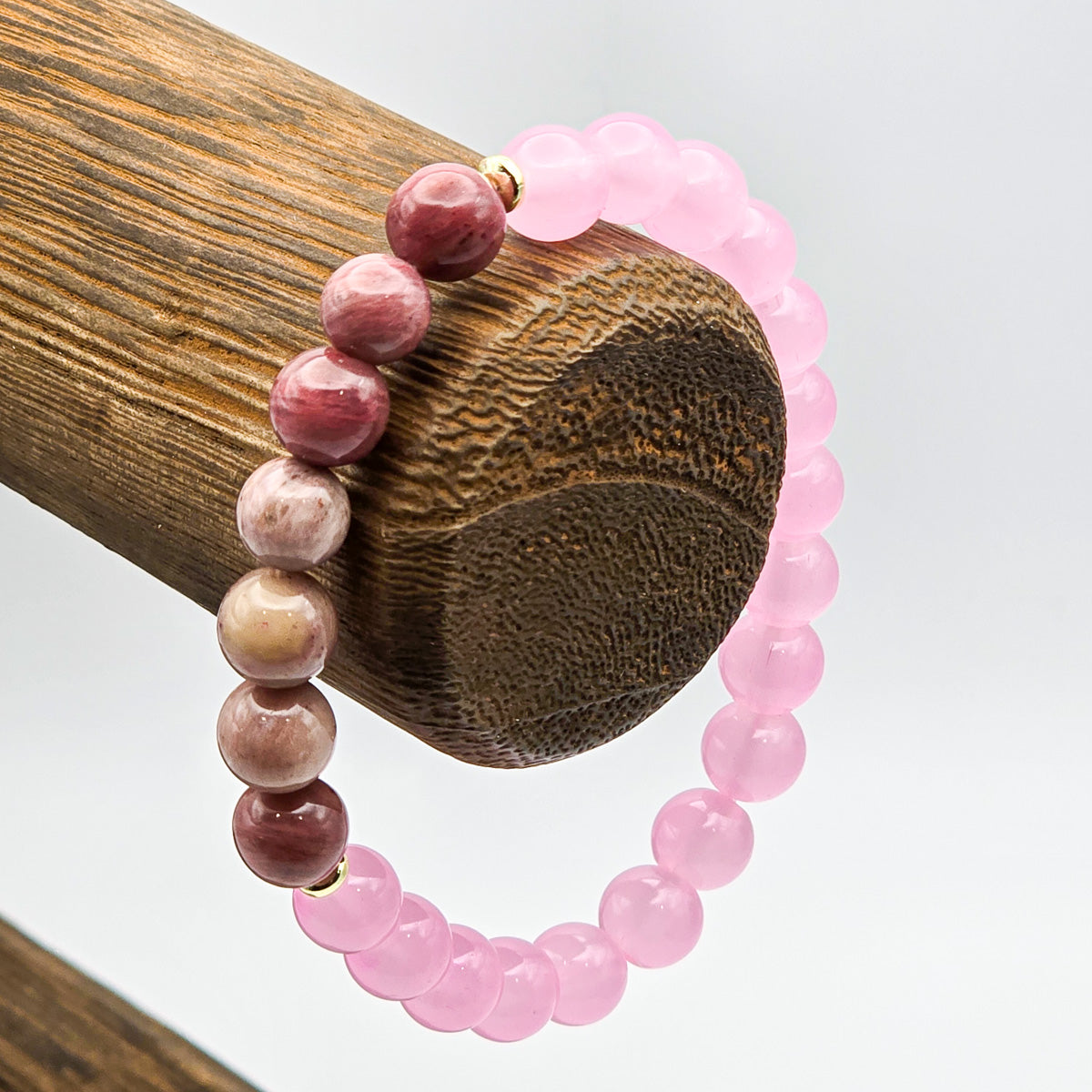 Rhodonite and pink bead bracelet on wooden holder - elegance and calm