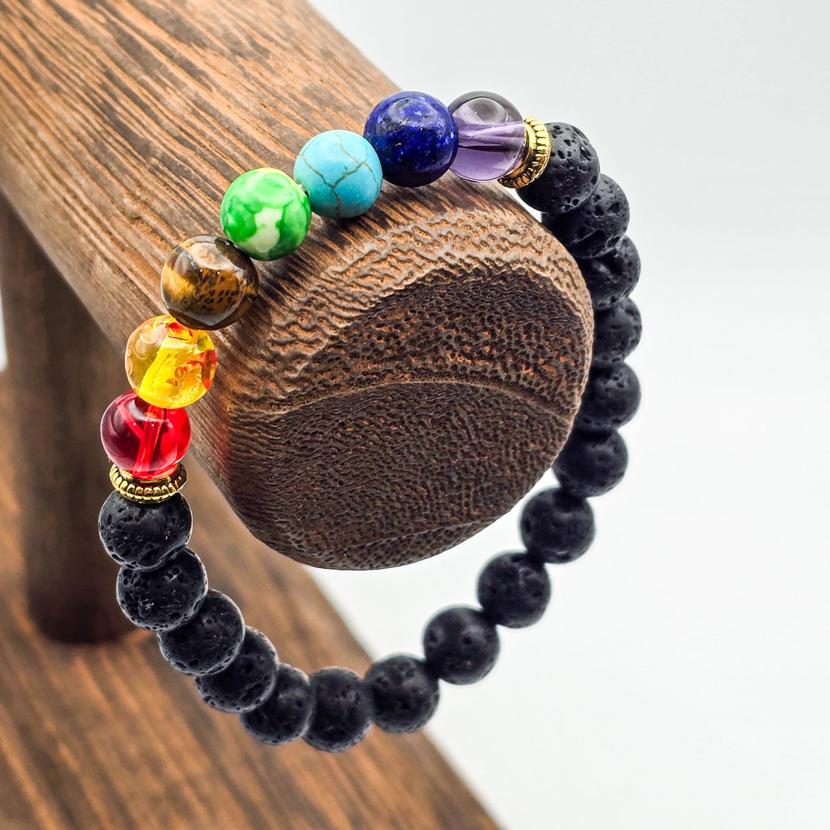 Chakra bracelet with lava stones on wooden holder - grounding energies