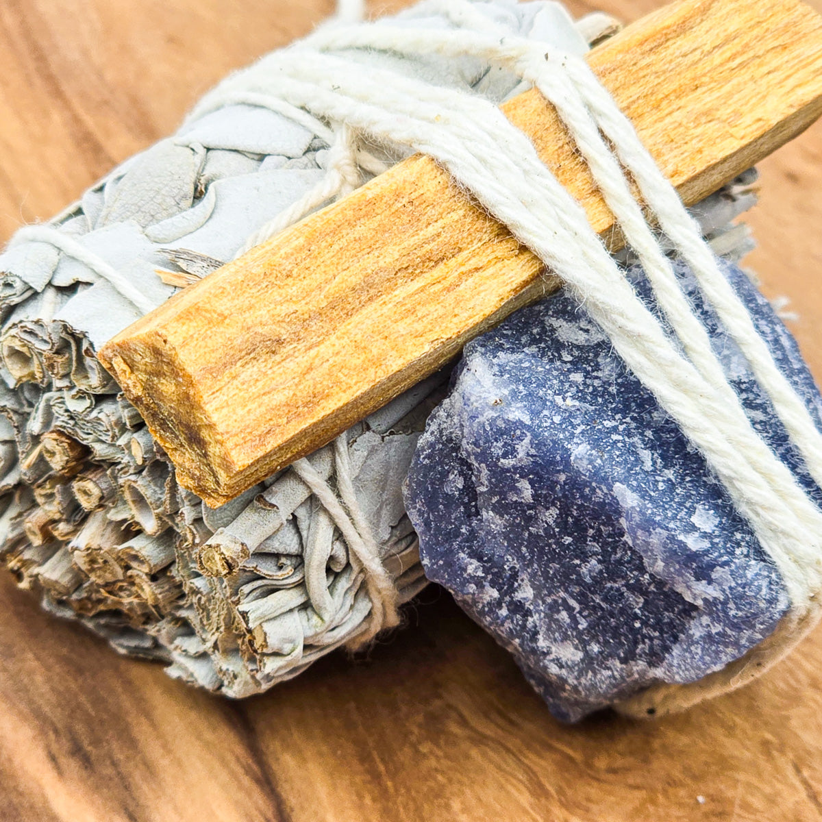 Sacred Cleansing Trio from the left - mini sage, palo santo, and aventurine on wood, closeup showing detail.