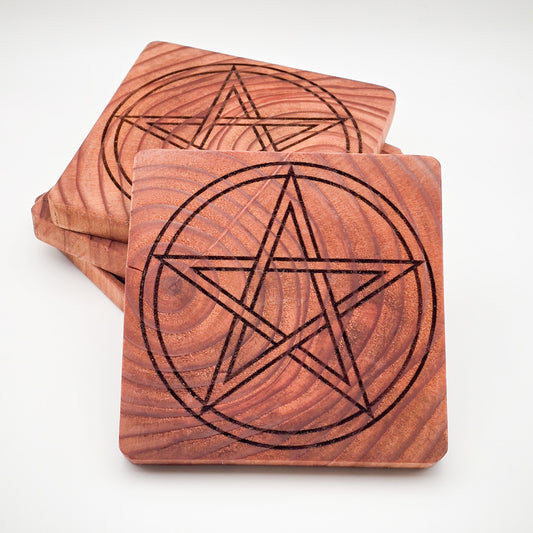 Stack of Redwood Pentagram Coasters with one standing upright, displaying intricate pentagram design.