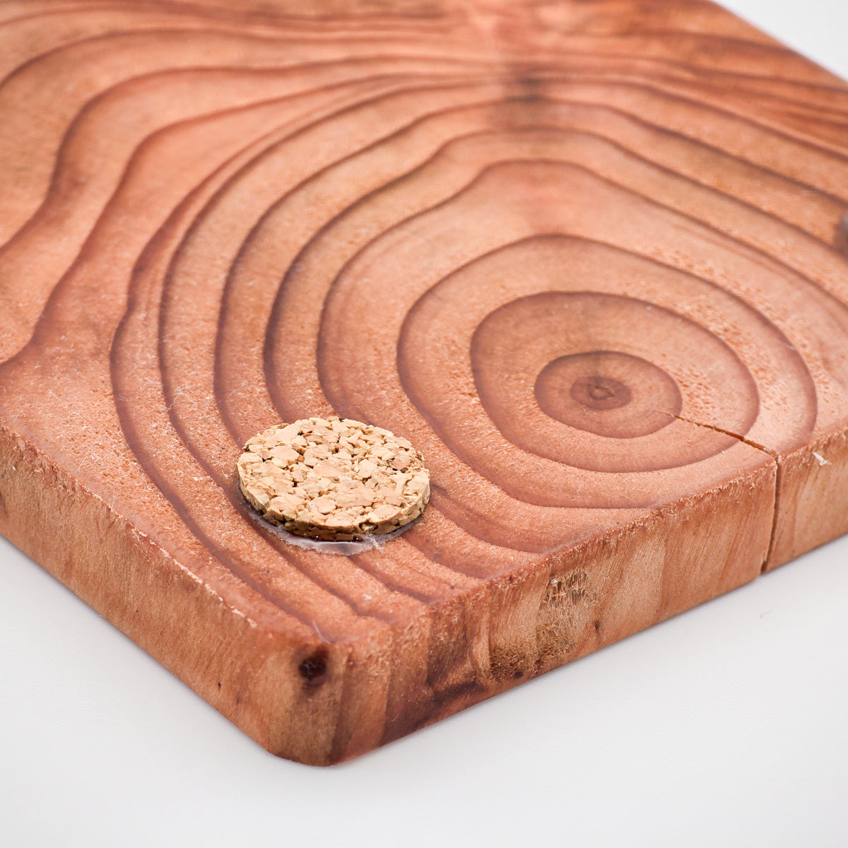 Close-up of natural cork base on artisan Redwood Coaster, ensuring table protection and stability.