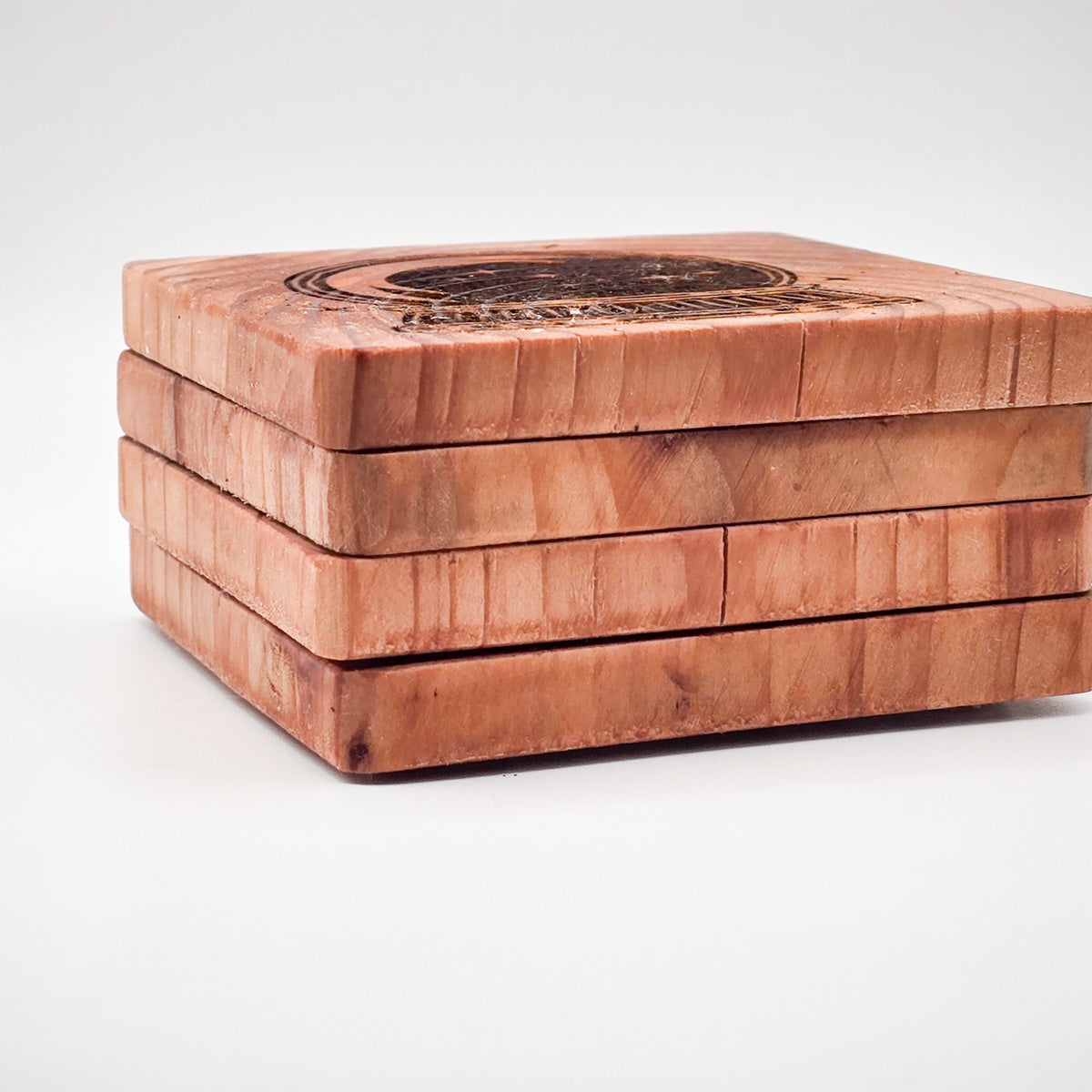 Set of four Redwood Coasters engraved with crystal ball design, displayed from above.