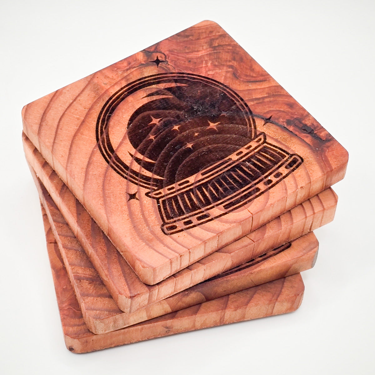 Stack of Crystal Ball Engraved Redwood Coasters showcasing detailed design.