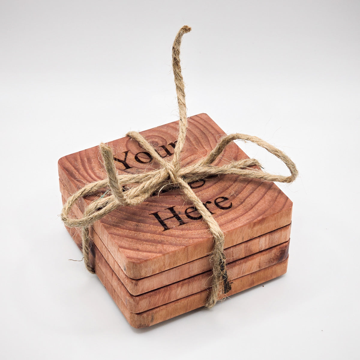 Stack of customizable Redwood Coasters, ideal for personal or corporate gifting, including hemp string.