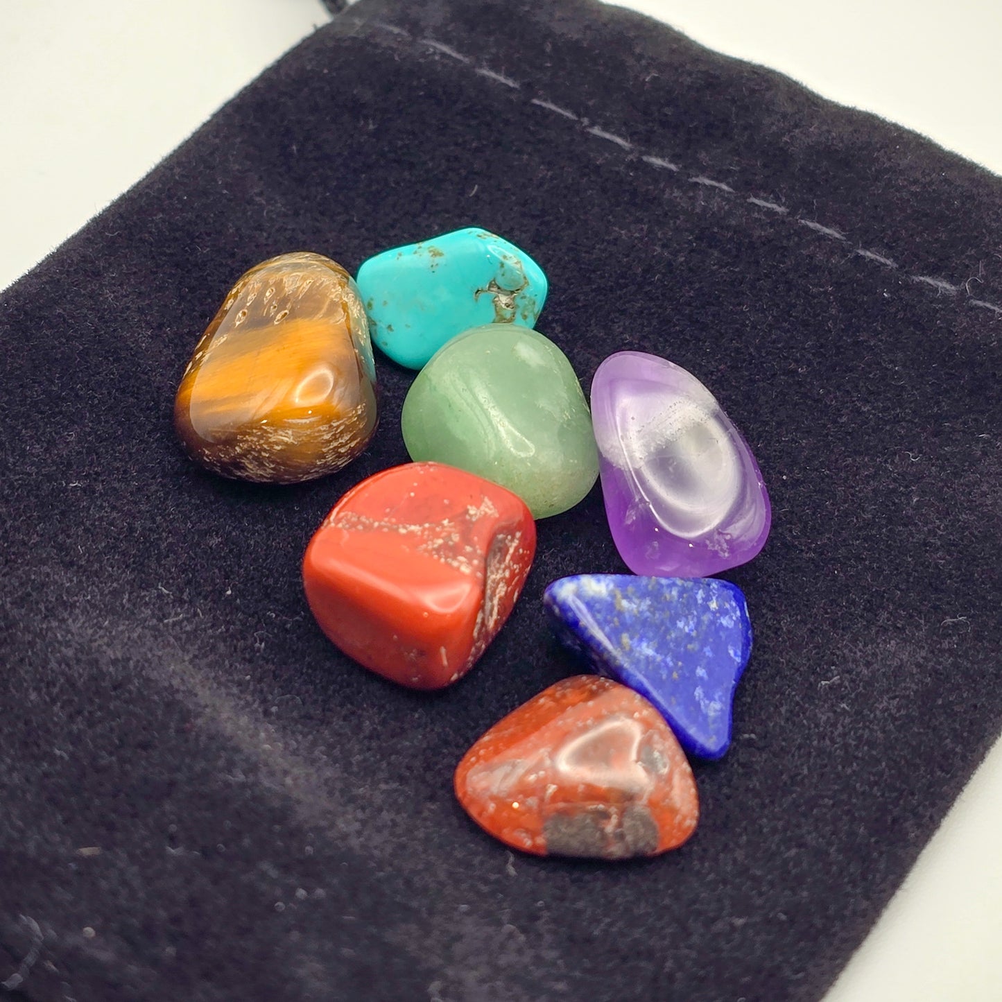 Close-up of miniature chakra stones on velvet bag